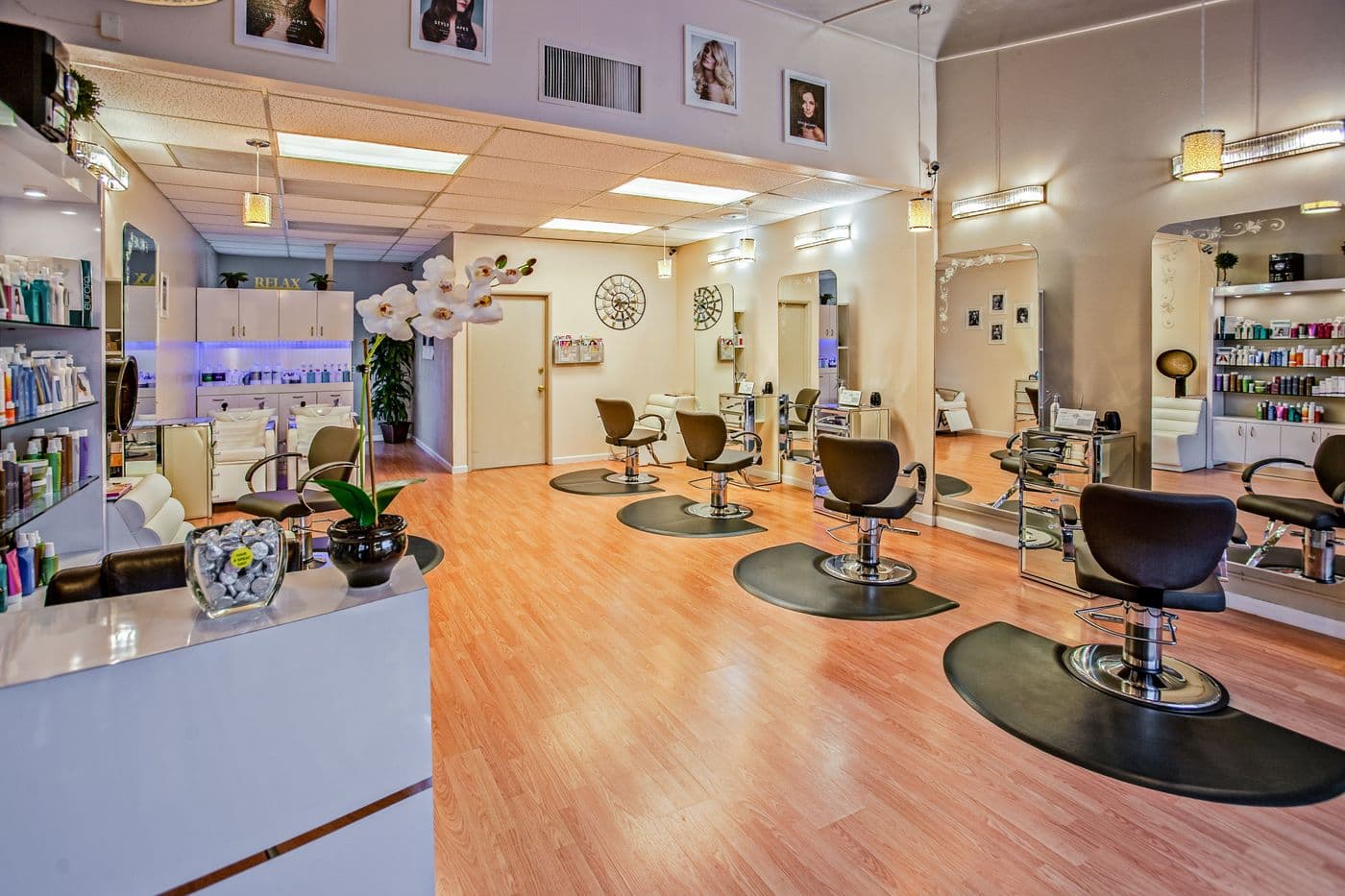 Un salón de belleza con sus sillas de corte frente a los espejos.